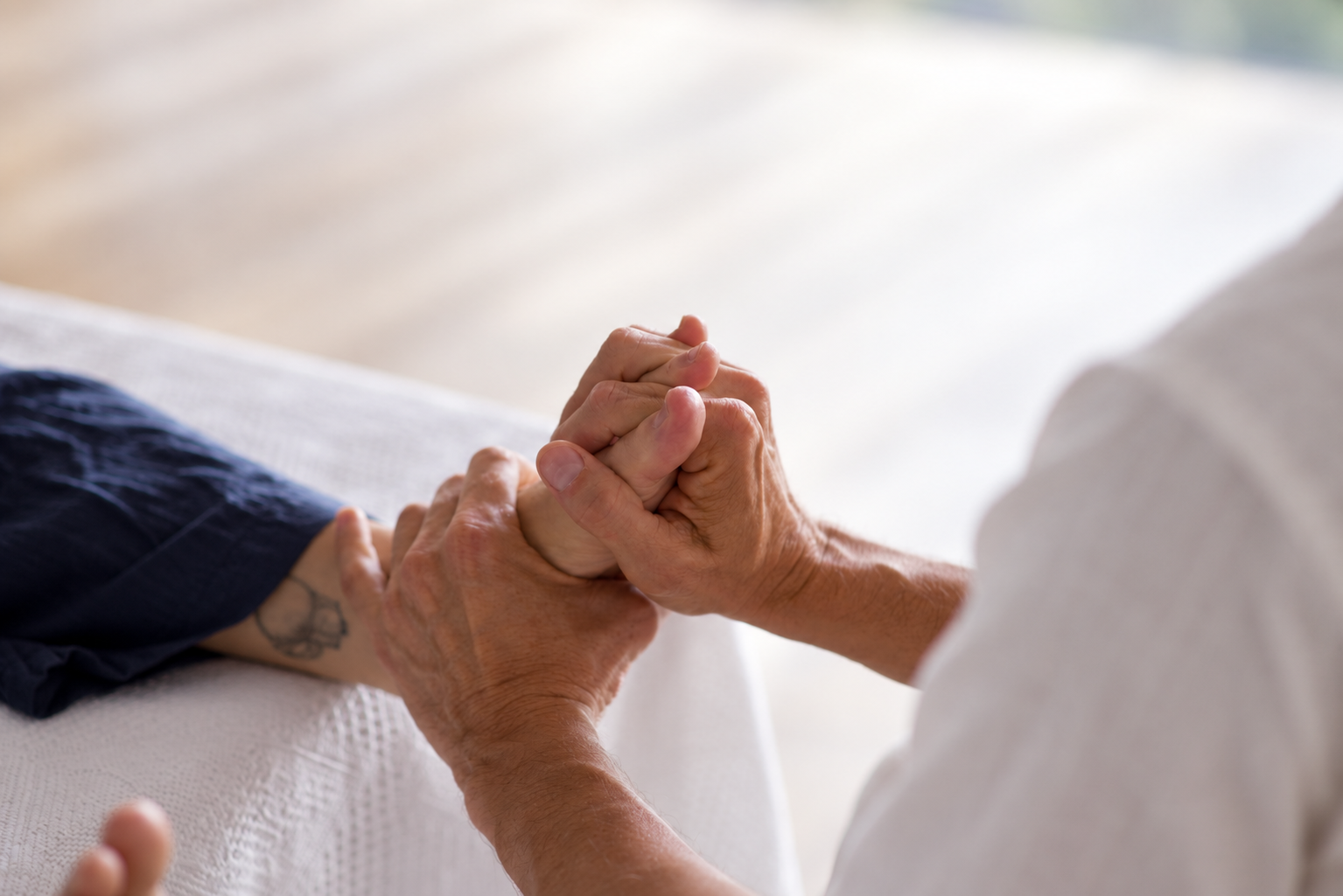 Hands holding a client's foot during a reflexology session