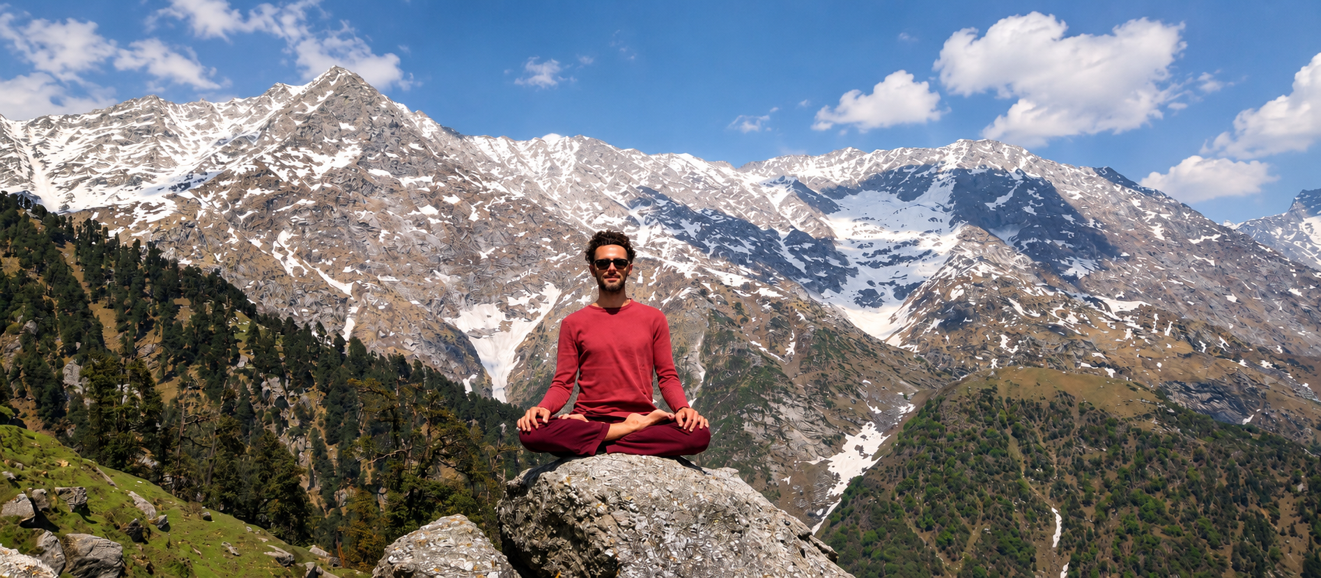 Orçun seated in meditation on a rock before the mountains